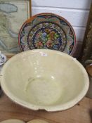 A large earthenware bowl and a glazed terracotta charger having floral pattern, both AF.