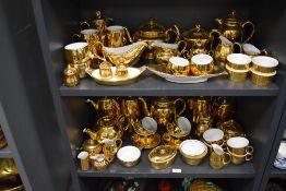 Two shelves of modern Royal Worcester porcelain tea wares having gilt glaze over porcelain