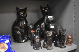 A selection of 20th century ceramic cat figures including black tabby cats with green and yellow