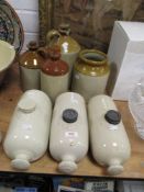 A trio of stone hot water bottles, and a collection of jars and flagons.