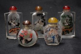 Five vintage Oriental glass snuff bottles with designs of storks, cockerels and similar.