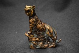 An Oriental brass tiger study, depicted mid roar and climbing a ledge.