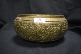 A 19th century Indian brass bowl decorated with foliage