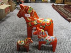 Three graduated mid century Nils Olsson Dala horse figures, tallest figure measures 26cm tall