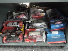 A shelf of modern mixed scale diecasts including Maisto 1:24, Pauls Model Art 1:18 Aston Martin