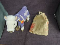 A modern Steiff Milka Lilac Cow having yellow tag 354014 and circular tag, wearing cow bell, with