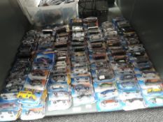 A shelf of modern Mattel Hotwheels diecasts, all on bubble cards, approx 100, some opened