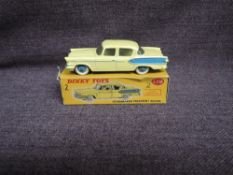A Dinky diecast, 179 Studebaker President Sedan, Yellow with blue Hubs, in original correct spot