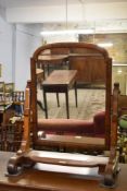 A Victorian mahogany swing dressing mirror, with arched mirror between shaped and pierced