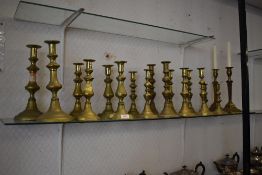 A selection of brass candlesticks. Including 19th century reeded column candlesticks. nine pairs