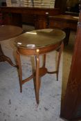 An Edwardian mahogany oval occasional table, raised on slender tapering supports linked by a small