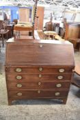 A George III mahogany bureau, the fall front with herring bone banding, over four long cockbeaded