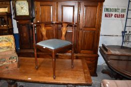 An Edwardian mahogany corner armchair of traditional design, with padded drop-in seat. Seat height