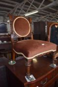 A Victorian mahogany bedroom chair, the back with circular upholstered section between shaped and