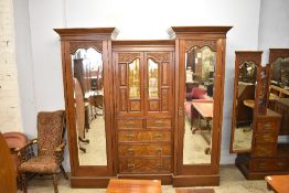 A large Victorian mahogany and walnut wardrobe, having central short glazed doors over. 2 / 3