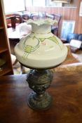 A 20th century cast metal and glass oil lamp, the two-part base cast with putti and repeating