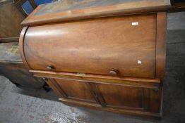 A Victorian Mahogany cylinder bureau, the curved front lifting to reveal an arrangement of drawers