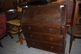 A 1940s oak bureau of traditional design, sold together with an Edwardian inlaid chair, modern