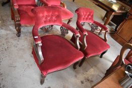 A pair of Edwardian stained mahogany tub form armchairs, upholstered in maroon material, the backs