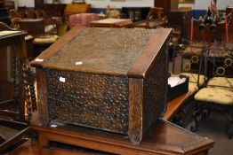 A Arts and Crafts oak and copper coal bin, with embossed foliate decoration. 39CM.