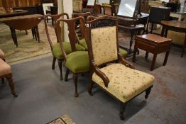 A late Victorian carved and moulded mahogany framed easy chair, upholstered in cream floral