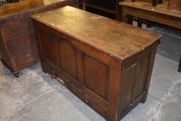 An 18th century oak mule chest, having a planked rectangular top over three fielded panels and two