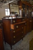 A reproduction bowfronted mahogany chest of five drawers, the upper drawer with central inlaid