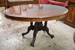 A Victorian stained mahogany oval loo table, the snap top action raised on five turned columns,