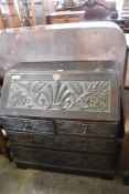 A Victorian carved and stained oak Bureau, of traditional arrangement, carved throughout with