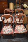 A set of four Victorian design balloon back dining chairs with pierced central splat, serpentine