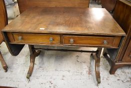 A 20th century mahogany sofa table. with reeded edge detail over two frieze drawers and raised on