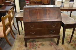 An early 20th century figured mahogany bureau with moulded geometric decoration, the fall front over