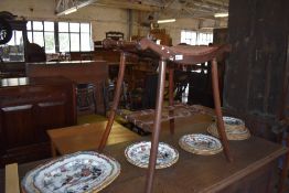 An Edwardian mahogany dressing stool, the concaved seat with end spindles over slightly splayed legs