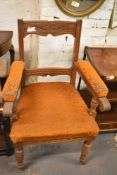 A late Victorian part upholstered oak armchair, having incised, carved and moulded decoration,