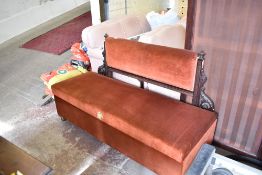 A Victorian oak box settee, the draylon padded back between carved and scrolled uprights, the hinged