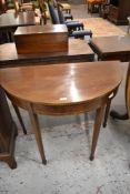 An Edwardian inlaid mahogany demilune side table with tapering square section legs terminating