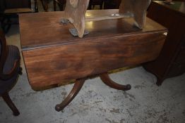 A 19th century mahogany pedestal Pembroke table, having turned column issuing for downswept