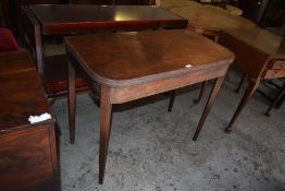 A late Georgian mahogany fold over tea table of rounded rectangular form with reeded edge detail
