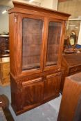 A Victorian glazed mahogany bookcase over cupboard, 203CM. X. 119CM.