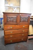 A Large Edwardian mahogany cupboard, having two stipple carved panelled doors over four long drawers