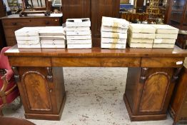 A Victorian figured mahogany pedestal sideboard, having three blind frieze drawers over arched