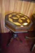 An octagonal Victorian design pedestal table with geometric marquetry top, lifting to reveal the