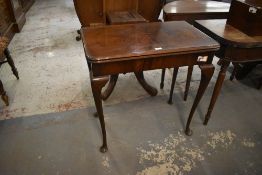 A 1920s figured walnut fold over card table, with typical swivel action and cabrial type supports