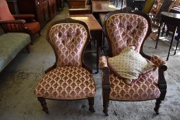 A pair of late Victorian carved mahogany his and hers easy chairs, with deep buttoned backs