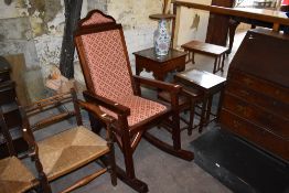 A large 20th century mahogany upholstered rocking chair, having studded construction. Seat height 64