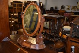A Victorian mahogany swing dressing mirror, of oval form with scrolled brackets. 61CM.