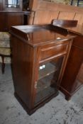 An Edwardian stained mahogany glazed music cabinet with shallow three quarter gallery over the