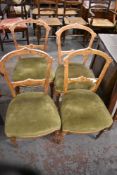 A set of four late Victorian inlaid mahogany chairs, the green upholstered bow fronted seats