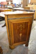 An Edwardian inlaid mahogany corner cupboard. the panelled door with inlaid swag and pendant design.