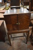 An early 20th century figured mahogany quarter veneered drinks cabinet, on stand, bearing label